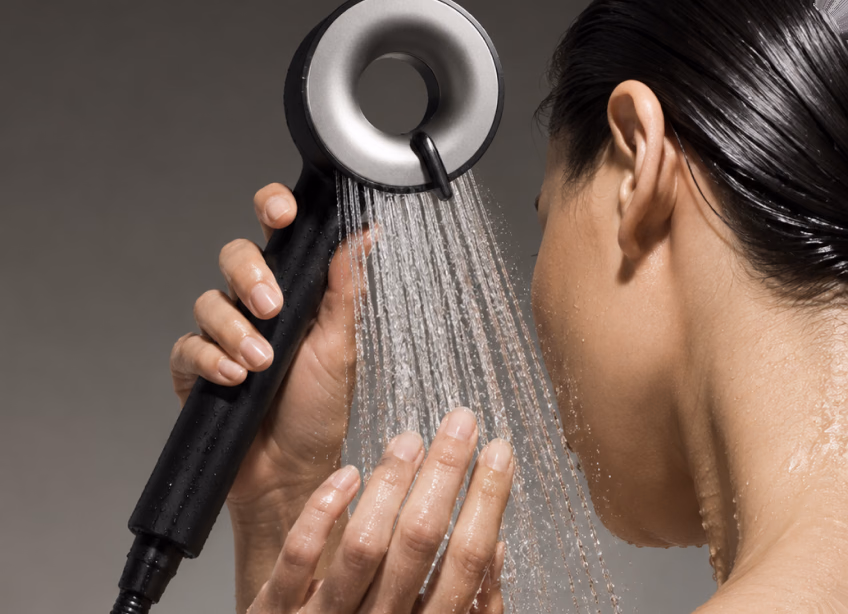 Woman rinsing her face under the IonDrops shower head
