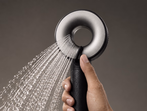 Hand holding the IonDrops shower head spraying water